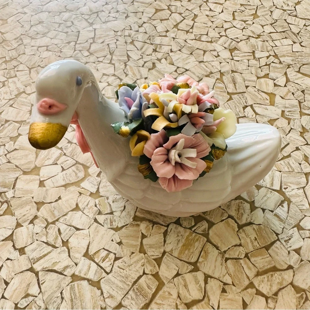 Beautiful little porcelain swan figurine with a back full of flowers!
